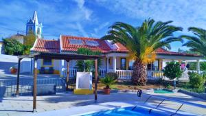 Figueira e Barros6 Persoons Vakantiewoning Portugal - Casa do Balão - en - Casa Pequeno Pintor的棕榈树和游泳池的房子