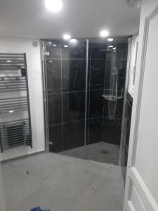 蒙特龙莱班Appartement dans maison atypique的带淋浴的浴室和玻璃门