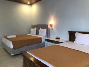 BatukliangBello Bungalow的酒店客房配有两张床和一张书桌