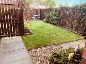 爱丁堡Home from home - Free Parking (near Edinburgh / Airport and Ingilston)的一个带栅栏的小后院和一个种有草的院子
