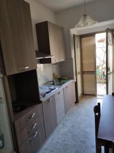阿曼泰阿Appartamento a 50mt dal mare的厨房配有木制橱柜、餐桌和用餐室