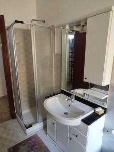 阿曼泰阿Appartamento a 50mt dal mare的浴室配有白色水槽和淋浴。