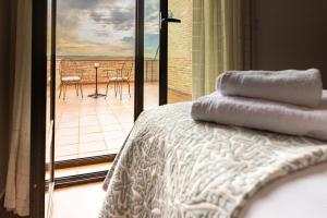 托莱多CASA RURAL Cigarral del Pintor的一间卧室设有一张床,享有阳台的景色