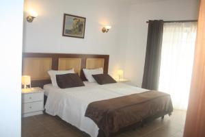 圣巴巴拉-迪内希Rustic Villa Guesthouse的卧室配有一张带白色床单和枕头的大床。