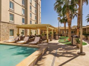 华雷斯城Hotel Mesaluna Near American Consulate的酒店设有带椅子的游泳池和凉亭。