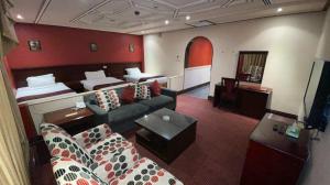 哈费尔巴廷Al Mansour Grand Hotel的酒店客房设有一张沙发和一张床