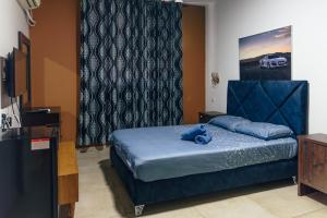 特拉维夫Central Laguardia Hotel的一间卧室配有一张蓝色的床,上面有泰迪熊
