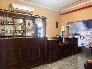 特拉维夫Central Laguardia Hotel的酒吧设有大型木制柜台,提供酒精饮品
