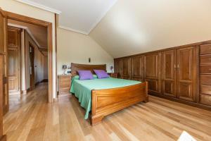 SevaresEl Pongallin ideal para familias的一间卧室配有一张带紫色枕头和木制橱柜的床。