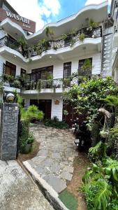 大叻Wasabi House - Homestay bên chợ đà lạt的白色的建筑,旁边是植物