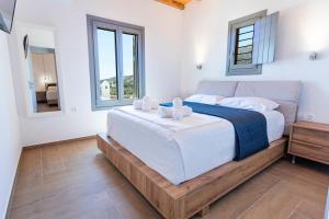 利瓦迪奥SeaeyeVillas 2的一间卧室配有一张带白色床单的大床和两个窗户。