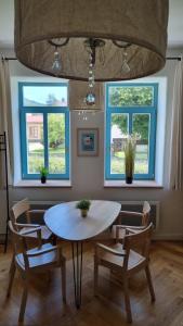 卢捷拿纳德德斯努5 stylových apartmánů v srdci Jeseníků的一间带桌椅和2扇窗户的用餐室