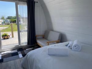金斯布里奇Cosy Glamping Pod with shared facilities, Nr Kingsbridge and Salcombe的卧室配有床、椅子和窗户。
