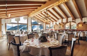 摩德纳迪-坎皮格里奥水晶皇宫酒店的用餐室设有桌椅和窗户。
