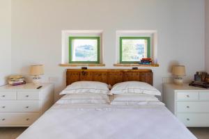 CollazzoneVilla meraviglia的卧室配有白色床和2扇窗户