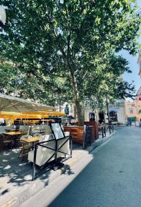 阿尔勒Duplex de charme 80m2 au coeur d'Arles, 2 chambres的城市街道上的一组桌子和遮阳伞