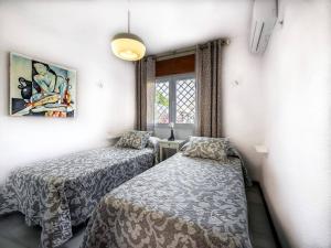 格拉纳达Casa Limonero con parking gratis junto a centro histórico的一间卧室设有两张床和窗户。
