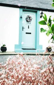 多尼戈尔New Listing - Ladybird Cottage - Donegal - Wild Atlantic Way的一座带花圈的蓝色门的房子