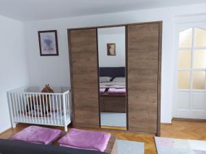 锡盖特堡Viktória Apartman的一张大镜子,放在一个配有婴儿床的房间