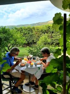 培拉特Hotel Vila Arbri的坐在桌子上吃食物的两个人