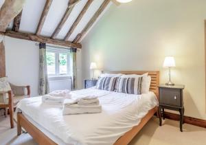 SuttonBrand Barn Sutton的卧室配有一张白色大床和两条毛巾