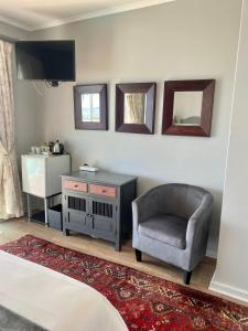 莫塞尔湾三蓝色旅馆的一间卧室配有椅子、书桌和镜子
