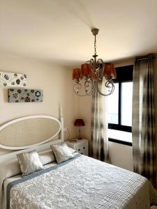 托罗克斯科斯塔Apartamento Lujo Calaceite的一间卧室配有一张带吊灯和窗户的床。