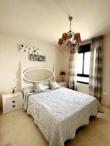 托罗克斯科斯塔Apartamento Lujo Calaceite的卧室配有白色的床和吊灯。