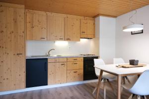 上盖斯特尔恩Hubertus 112的厨房配有木制橱柜和桌椅