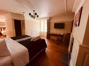 米内拉尔德尔蒙特Hotel Real Del Monte的一间卧室配有一张床、一张书桌和一台电视