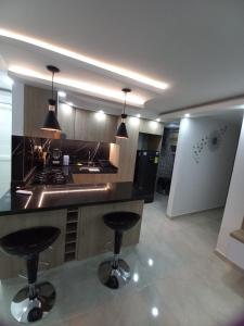 内瓦HERMOSO APARTAMENTO NUEVO AMOBLADO Conjunto Goya 503 Neiva的厨房配有2把吧台凳和台面