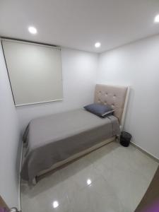 内瓦HERMOSO APARTAMENTO NUEVO AMOBLADO Conjunto Goya 503 Neiva的白色墙壁的房间里一张小床