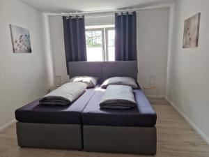 新明斯特Nordunterkunft的一张床上有两个枕头的房间