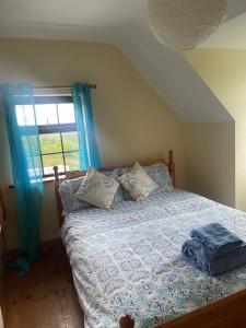 肯梅尔Moriarty’s的一间卧室配有一张带蓝色床单的床和一扇窗户。