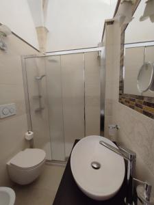马丁纳弗兰卡ROSSINI GUEST HOUSE的带淋浴、卫生间和盥洗盆的浴室