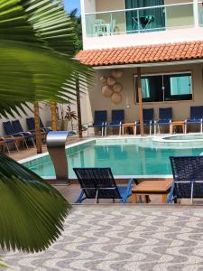 马拉戈日Pousada Concha Dourada的一个带椅子的游泳池和一间酒店