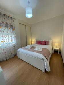 维亚纳堡B Apartamentos Castelo的卧室配有一张带粉红色枕头的大床