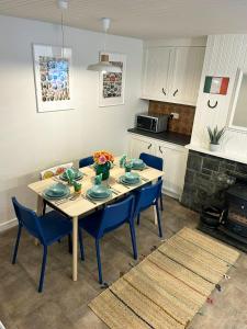 丁格尔Foxy View in Dingle Town!的一张带蓝色椅子的餐桌和一间厨房