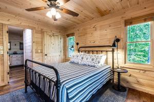 蓝岭Luxe Family Cabin 8 min to Downtown Blue Ridge的一间卧室配有一张床和吊扇