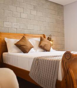 伦索伊斯Vila Pugliesi Hotel Boutique的一间卧室配有带白色床单和枕头的床。