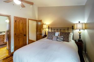 斯诺马斯村Snowmass Village 19E的一间卧室配有一张带两盏灯的大型白色床。