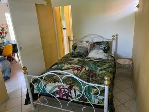 圣罗斯Paradis le Clodyo的小卧室配有一张带绿床罩的床