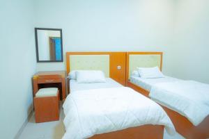 梭罗卡蒂卡伊斯兰教旅馆的小房间设有两张床和镜子
