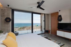 曼塔Eolia Sustainable Design Hotel的一间带大床的卧室,享有海景