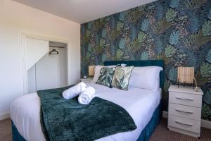 伯明翰Heartland House, 7 Spacious Bedrooms Sleeps 4 plus, near NEC, JLR,BHX的一间卧室配有一张带绿色图案墙壁的床