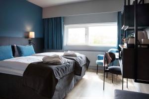 欧登塞欧登塞斯堪迪克酒店的一间卧室配有一张蓝色墙壁的床和一扇窗户