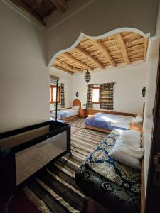 Akhendachou nʼAït OuffiAuberge NICE VIEW DADES的一间带两张床的卧室和大型天花板