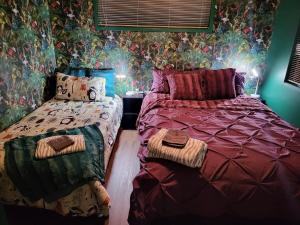 旺阿雷Hatea Treehouse的一间卧室设有两张床和鲜花墙