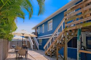 霍姆斯海滩Longboard的蓝色的建筑,设有木制甲板和桌椅
