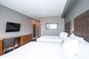 汉密尔顿桑德曼汉密尔顿酒店的一间酒店客房,设有两张床和电视